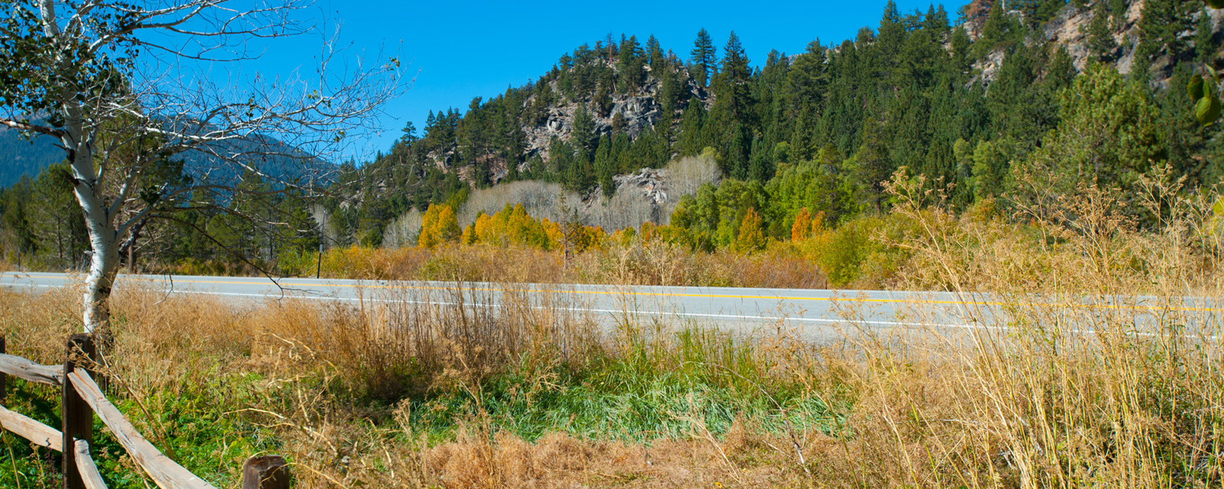 This is a generic image of a road with mountains behind it. 